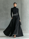 Gina – Vestido maxi de mujer negro con costuras blancas y cuello alto, mangas largas y cintura entallada